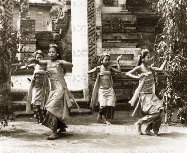 A traditional Balinese dance. Four Balinese women perform a dance outside a Hindu temple, dressed in traditional costumes with arrangements of flowers in their hair, Bali, Indonesia, July 1940., Lesser Sunda Islands (including Bali), Indonesia, South East Asia, Asia.