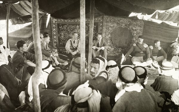 A council with Arab leaders. A delegation of British officials attends a council with Arab leaders at a camp in the desert. In the centre sits William Ryder McGeagh, District Commissioner in Jerusalem. British Mandate of Palestine (Israel), circa 1940. Israel, Middle East, Asia.