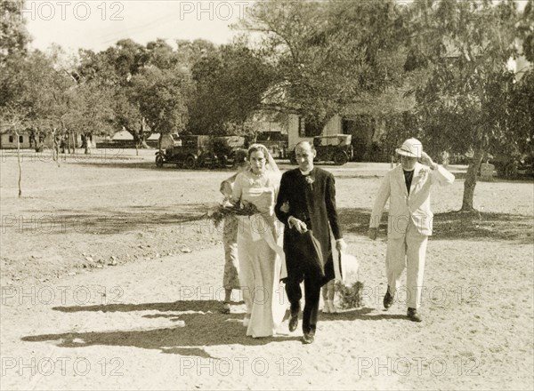 Joan arrives for her wedding, Tumkur. A British bride named Joan arrives at the church in Tumkur to marry Methodist missionary Norman Sargent. She holds the arm of a friend, Mr Cochrane, who is dressed in priest's attire. Tumkur (Tumakuru), Karnataka, India, 19 February 1935., Karnataka, India, Southern Asia, Asia.