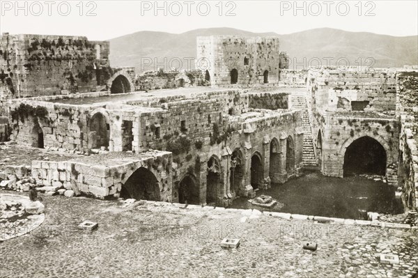 Inside the Krak de Chevaliers. The ruined interior of the Krak de Chevaliers, a prominent hill fortress in the Homs Gap. Once the headquarters of the Knights Hospitaller during the Crusades (1095-1291), it controlled the road to the Mediterranean and is one of many fortresses that formed a defensive network along the border of the old Crusader states. Homs (Hims), French Mandate of Syria, 1944. Hims, Syria, Syria, Middle East, Asia.