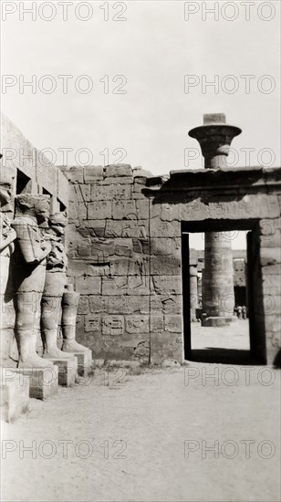 Temple of Ramesses III at Karnak. A line of eroded stone statues guard a courtyard in the Temple of Ramesses III, one of several buildings belonging to the Karnak Temple complex. Karnak, Egypt, February 1945., Qina, Egypt, Northern Africa, Africa.