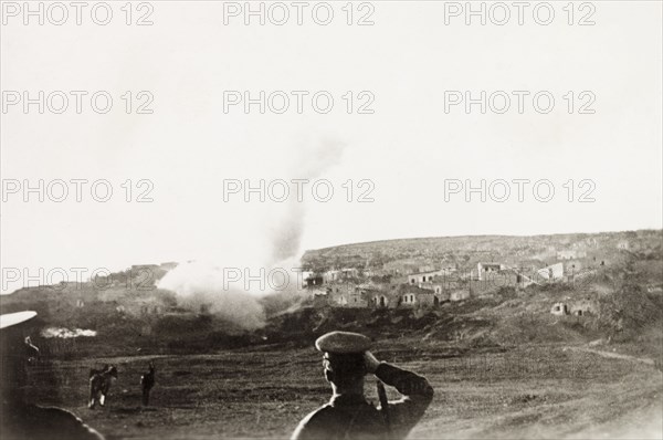 Mortar attack on a Palestinian village. British military officers look on as their mortar shell destroys a rebel dwelling in the Palestinian settlement of "Ein Durah", sending a large plume of smoke into the air. British Mandate of Palestine (Middle East), circa 1938., Middle East, Asia.