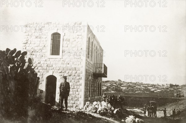 A condemned house in Nablus. A British Army officer stands on guard outside a house on the outskirts of Nablus. The Royal Engineers had condemned this building to demolition, a measure taken to clamp down on Arab dissidence during the Great Uprising (1936-39). Nablus, British Mandate of Palestine (West Bank, Middle East), circa 1938. Nablus, West Bank, West Bank (Palestine), Middle East, Asia.