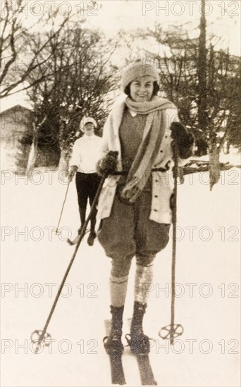 Skiing in Eastbourne. Beryl Phelps, wrapped warmly in a woollen hat, scarf and gloves, skis with friends on a snowy winter's day in Eastbourne. Eastbourne, England, circa 1922. Eastbourne, Sussex, England (United Kingdom), Western Europe, Europe .