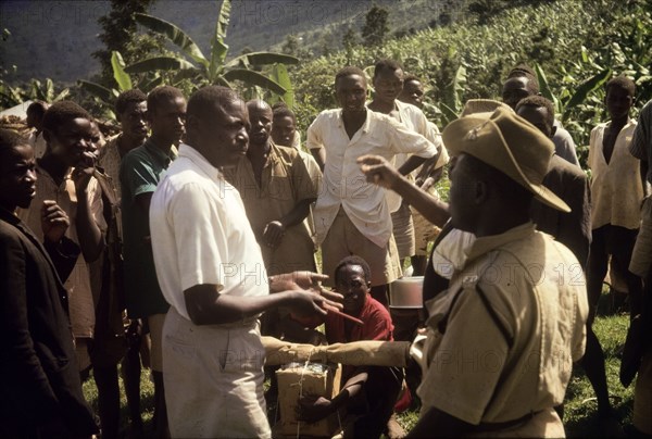 Recruiting porters at Budadiri. A Ugandan Forest Ranger negotiates for porters with a chief at Budadiri, one of the highest villages on the slopes of Mount Elgon. The expedition was organised to erect an aluminium rondavel on the mountain for use by the Uganda Mountain Club. East Uganda, 1962., East (Uganda), Uganda, Eastern Africa, Africa.