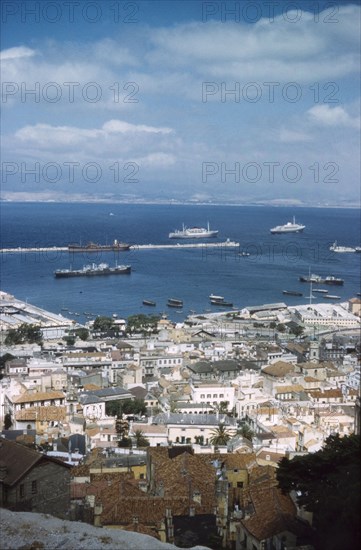 A view over Gibraltar town and harbour. View from high ground across the city and harbour of Gibraltar, "the first port of call for all ships bound for the Indian Ocean". Gibraltar, July 1958. Gibraltar, Gibraltar, Gibraltar, Mediterranean, Europe .