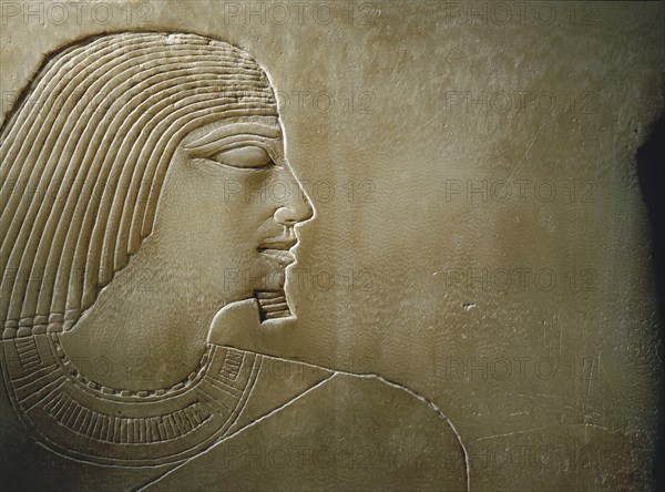 An alabaster panel decorated in sunk relief with a profile head and torso of Rawer