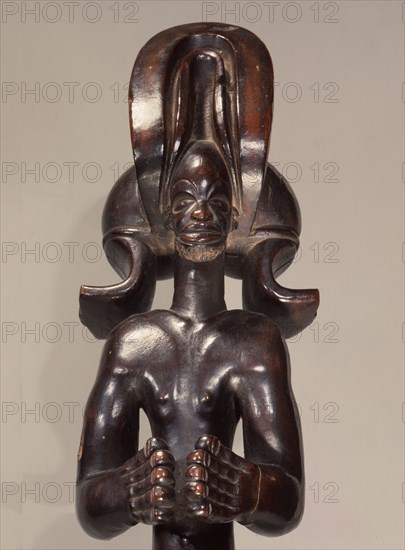 Wood figure wearing headdress that is characteristic of Chokwe chiefs and also found on important masks