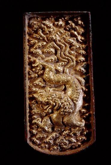 Gilded bronze plaque, possibly a buckle, decorated in relief with three clawed dragon and clouds