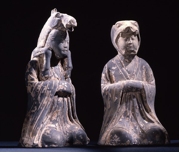 Two male kneeling figures representing animals of the zodiac