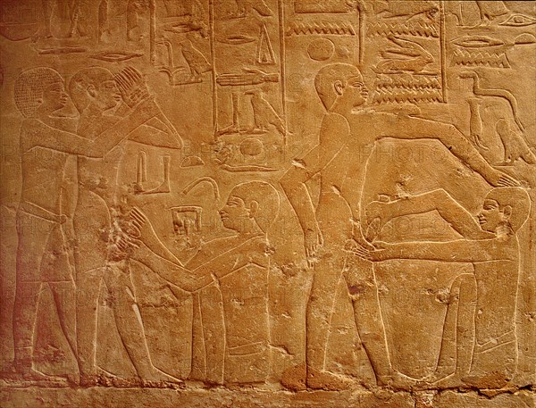 A detail of a relief in the tomb of Ankhmahor at Saqqara depicting a priest performing ritual circumcision on a young boy