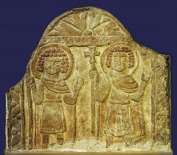 Limestone relief depicting a pair of saints holding the cross