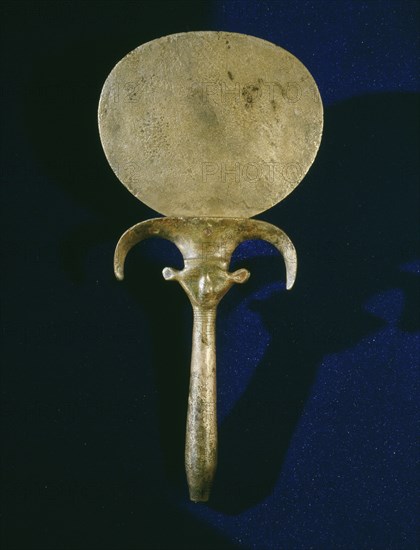 Polished bronze mirror with handle in the shape of a papyrus stem incorporating a double sided image of the face of the goddess Hathor