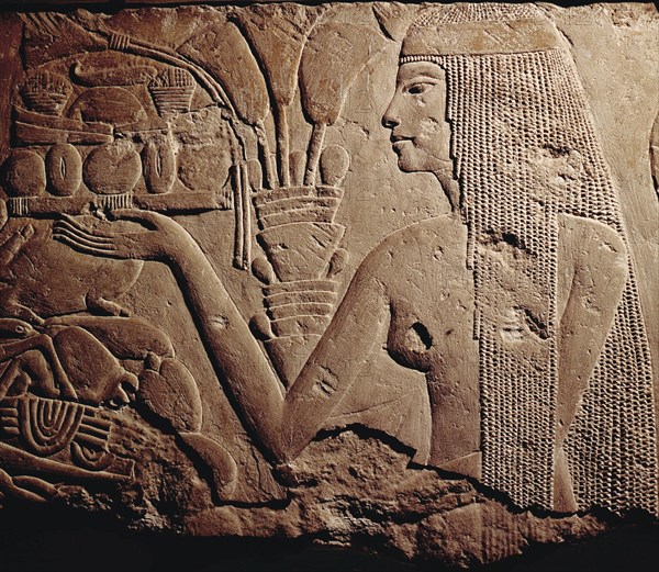 Fragment of a relief showing a woman bearing offerings