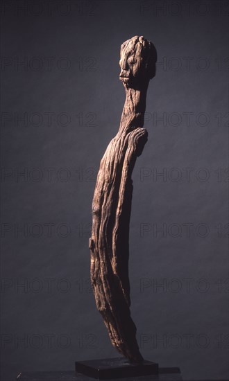 A wood sculpture of a man, possibly an ancestor figure