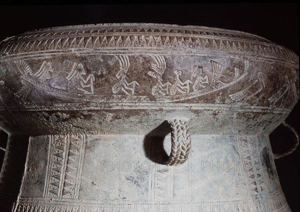 Detail of decoration on a Dong Son drum, depicting figures with feathered headdresses in a boat