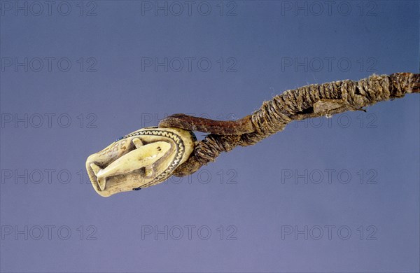 Ivory toggle or canoe fastener in the shape of a seals head, decorated with low relief carving of a whale on the reverse