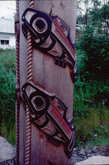 Detail of totem pole showing carving of two salmon