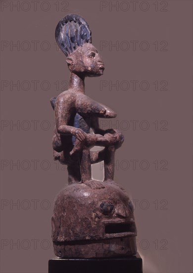 Epa helmet mask with typical mother and child motif, used in a masquerade honouring lineage ancestors in the northern Ekiti Yoruba area