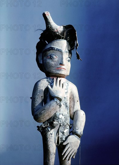 Carved wooden figure with movable limbs and a bird perched on its head