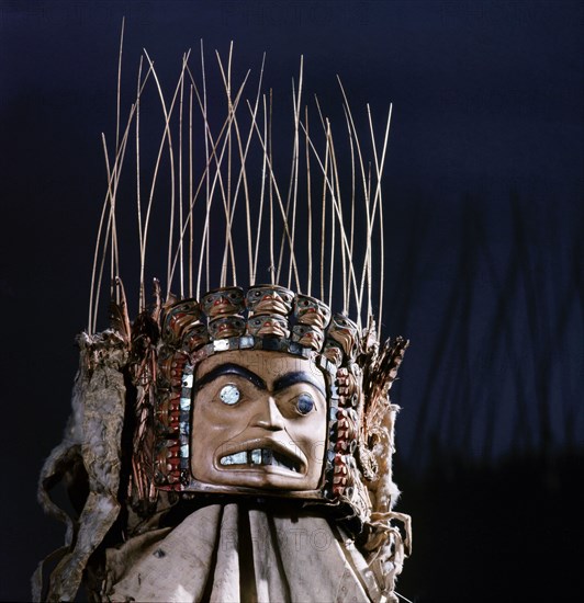 Chiefs headdress with humanoid face surrounded by a row of abalone shell and a double row of smaller faces