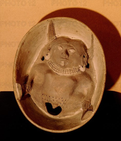 Shallow bowl with relief modelled woman at base with prominent vulva