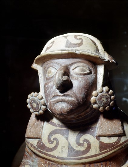 Detail of a Mochica effigy jar showing a high status individual wearing an elaborate headdress and two large ear discs