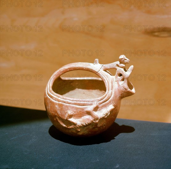 Unglazed jug with modelled figures of a seated man and a crocodile