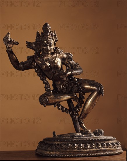 Vajravarahi dancing naked on her toes holding a kartrika knife in her right hand and a skull cup in her left