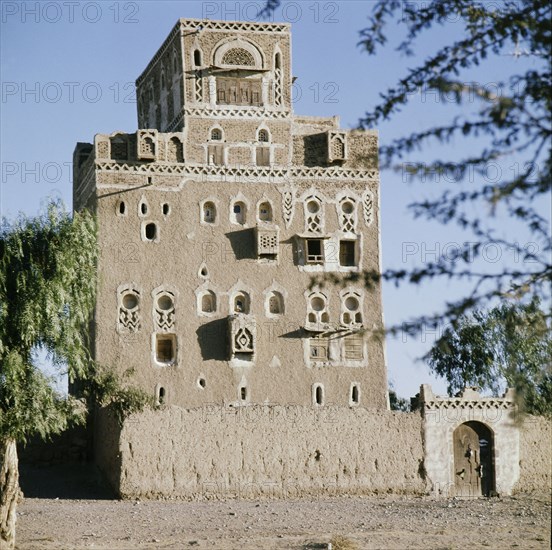 Multi-storeyed house with incised plasterwork and ornate window arches, in a village near San'a