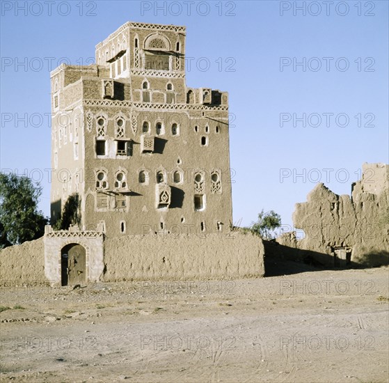 Multi-storeyed house with incised plasterwork and ornate window arches, in a village near San'a