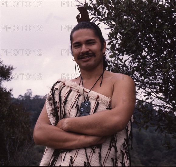 A Maori man wearing traditional dress and a hei-tiki pendant