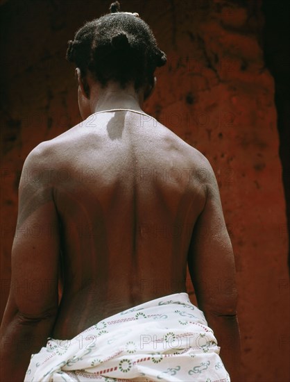 The wife of a Benin chief displays her body decorations