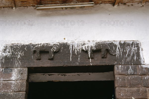 Detail of fine masonry Inca doorway with two pumas carved on the lintel, indicating an elite residence