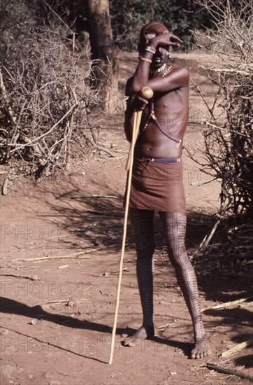 The hairstyle and beadwork of this Masai man indicate his status as a warrior