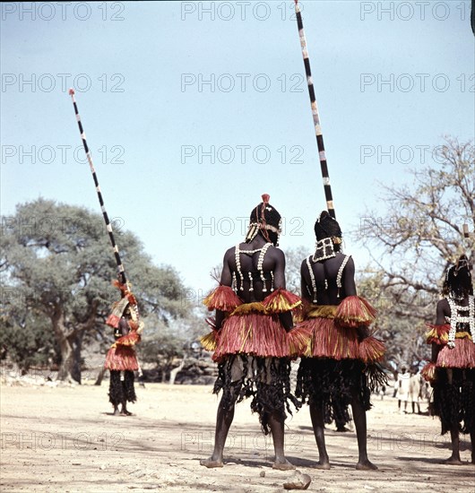 Dogon masqueraders perform in a ceremony known as a dama, which draws the souls of honoured dead away from the village and brings prestige to their families