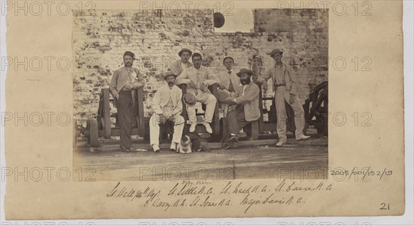 Group of men in civilian clothes pose against a wall