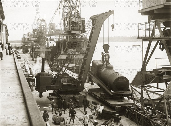 Steam engine lowered onto dockside, Mombasa