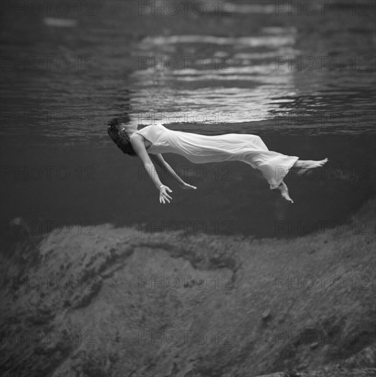 Weeki Wachee, Florida:  1947.
An underwater fashion photograph of a woman, wearing a long gown, floating on her back at the Weeki Wachee Spring in Florida.