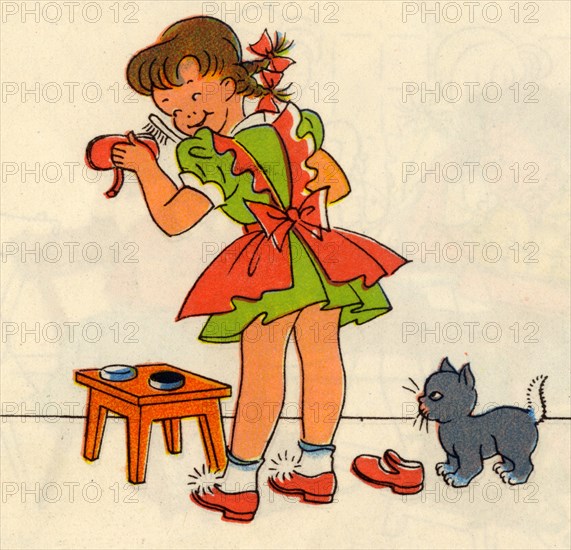 Girl Polishes her shoes as a cat looks on
