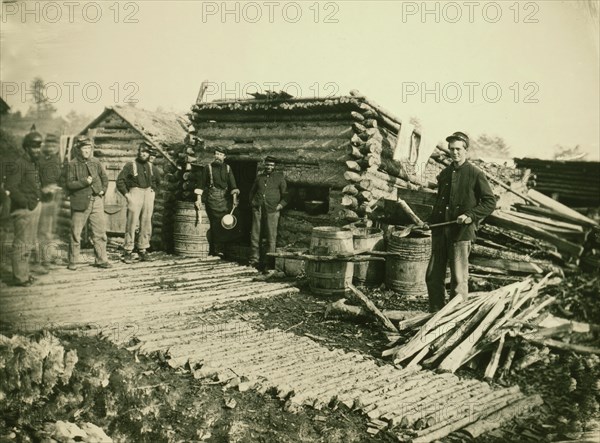 Civil War camp of the 6th N.Y. Artillery at Brandy Station, Virginia, showing Union soldiers in front of log company kitchen 1864