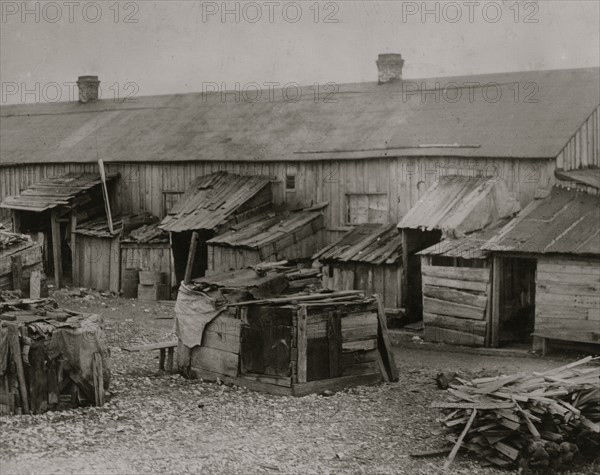 Father taking it easy at home while his two girls work in the cotton mill. 1911