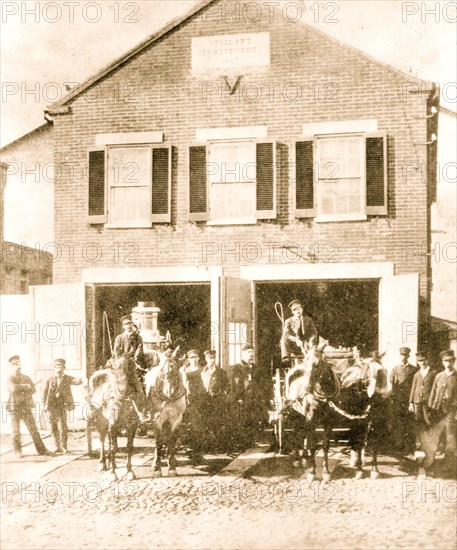 Fireman with firefighting equipment in front of firehouse, in the Washington, D.C.  1910