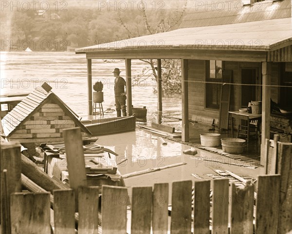 Flood with people looking out over a rover overflowing its banks 1924