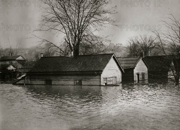 Floodwaters rise around a garage and home 1924