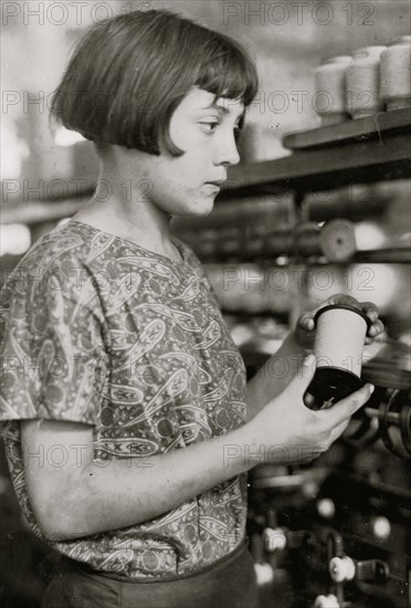 Girl holds a spool of silk thread 1924