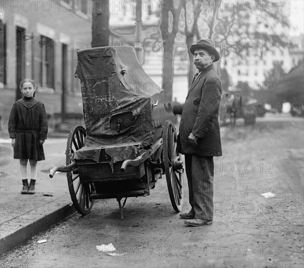 Italian Organ Grinder Has his Instrument covered with Tarp