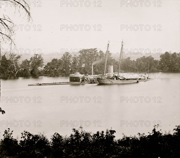 James River, Virginia. U.S. monitor CANONICUS taking on coal from a schooner 1864