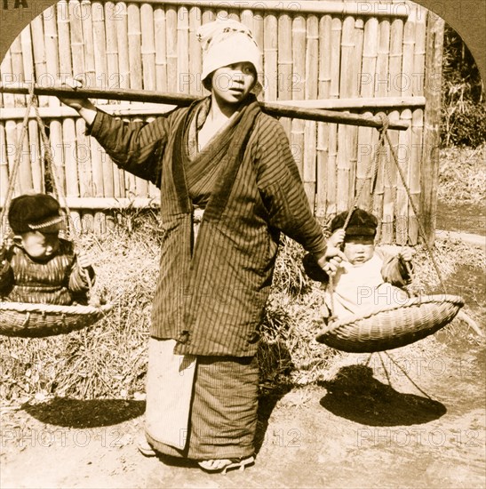 Japanese woman carrying two babies on yoke, Japan 1928