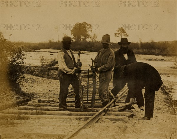 Military railroad operations in northern Virginia: men using levers for loosening rails 1863